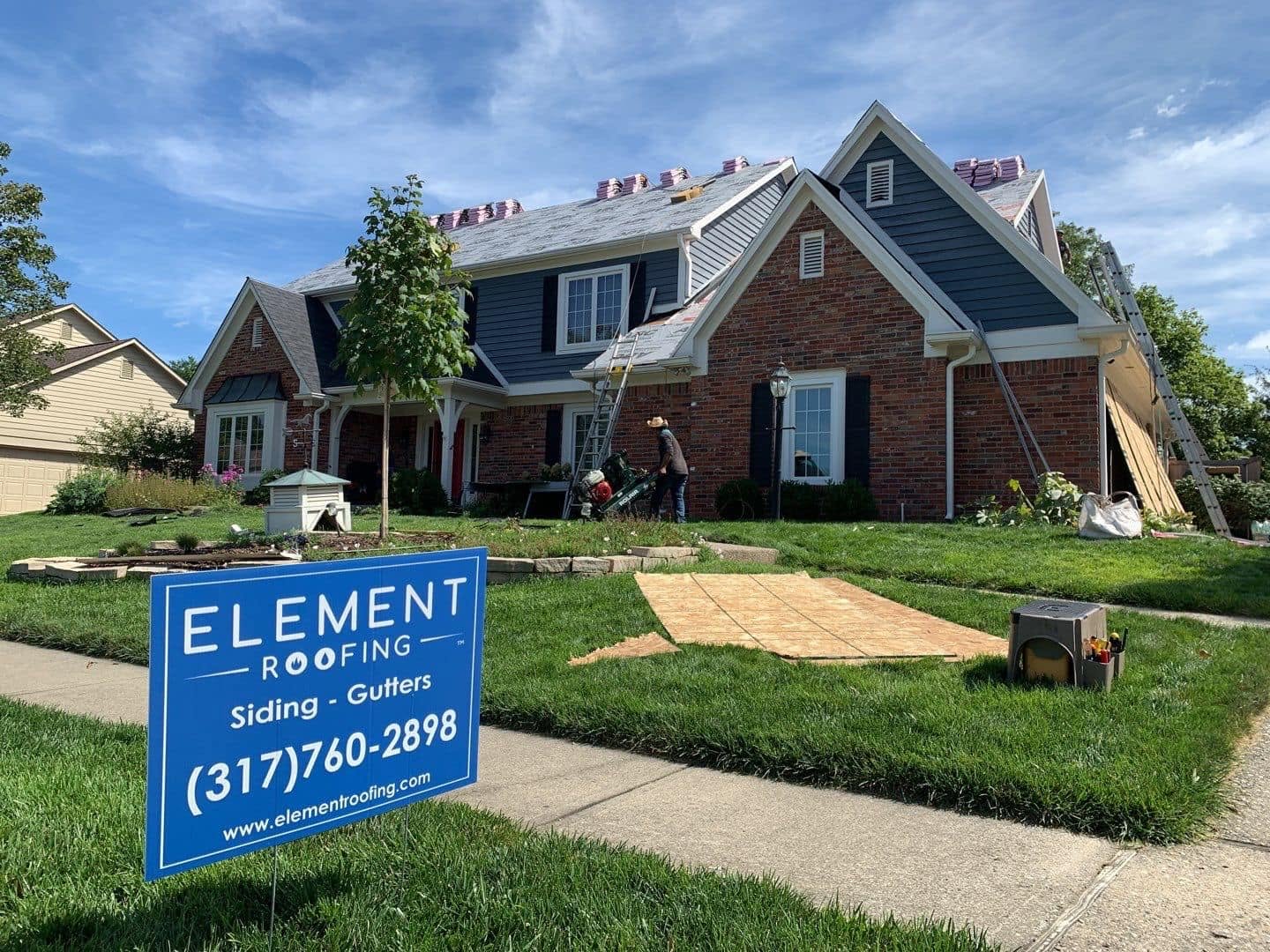 House with a new roof, Element Roofing sign in front of the house